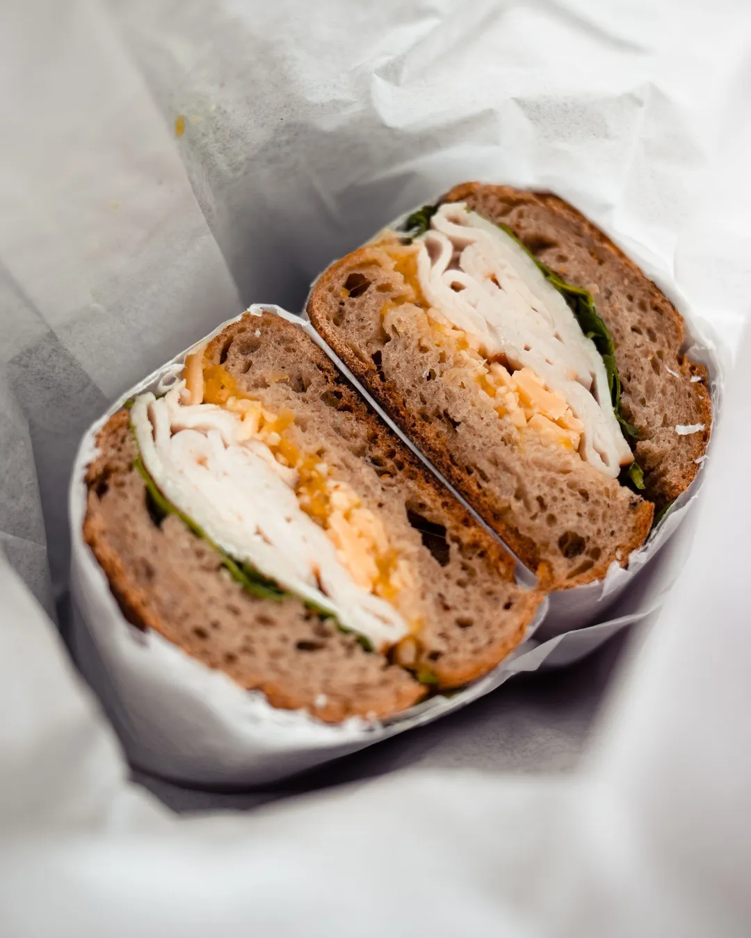A sandwich wrapped and served in deli paper